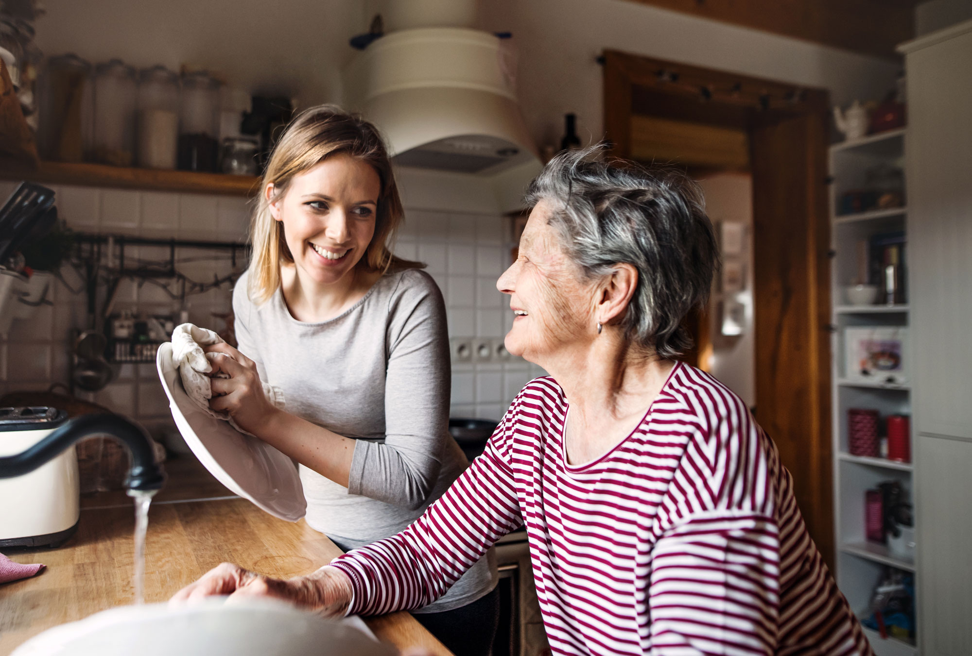 Barnebarn hjelper bestemor med oppvask. Foto