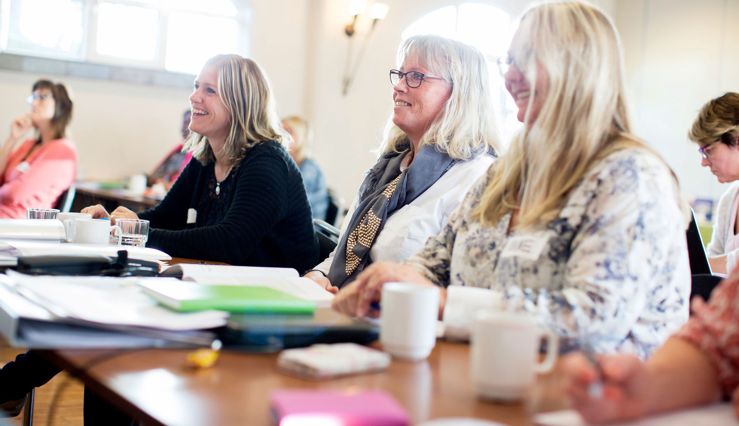 Damer sitter i klasserom. Foto