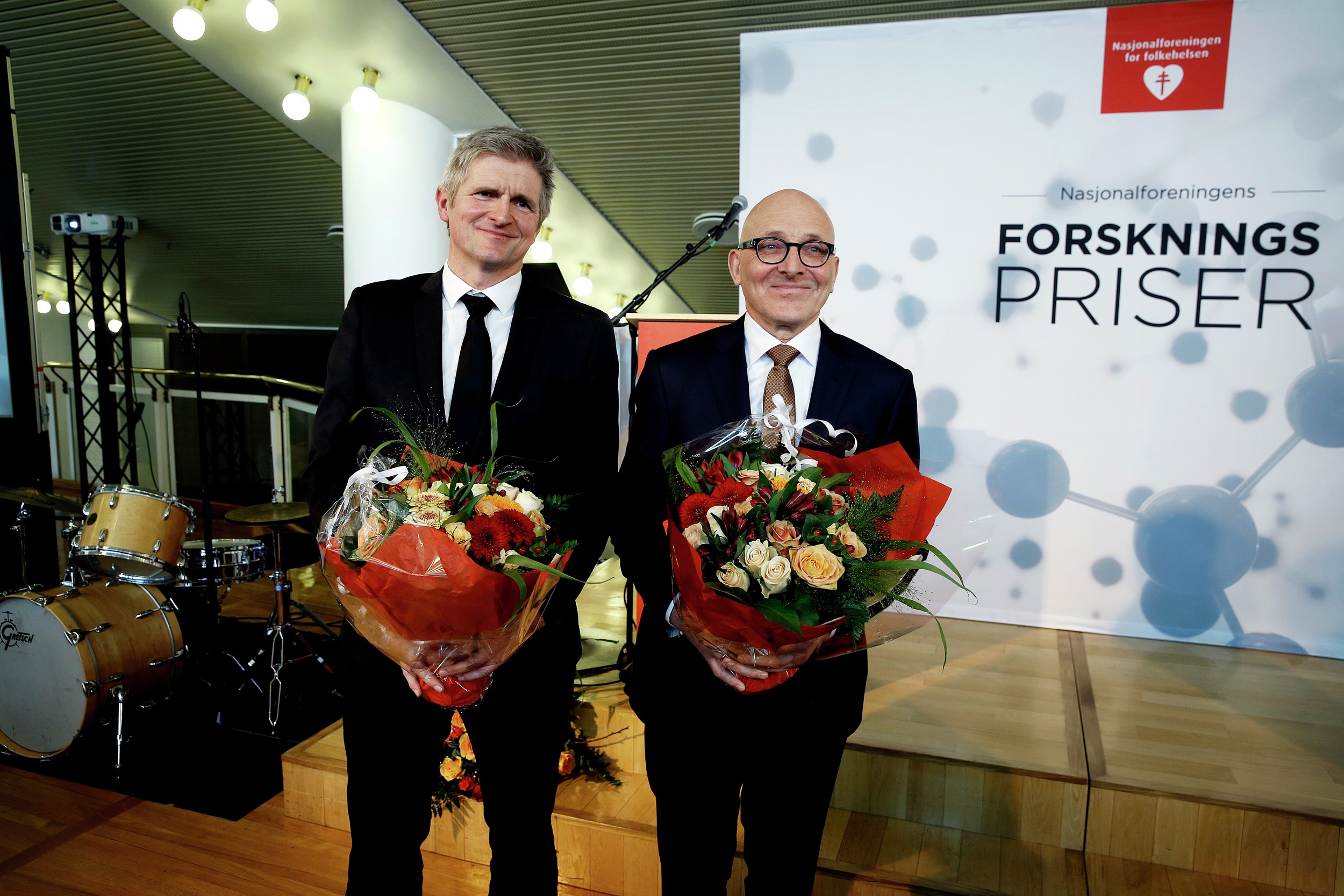 Geir Selbæk og Kaare Bønaa står med en blomsterbukett etter å ha mottatt Nasjonalforeningesn forskningspriser. Foto