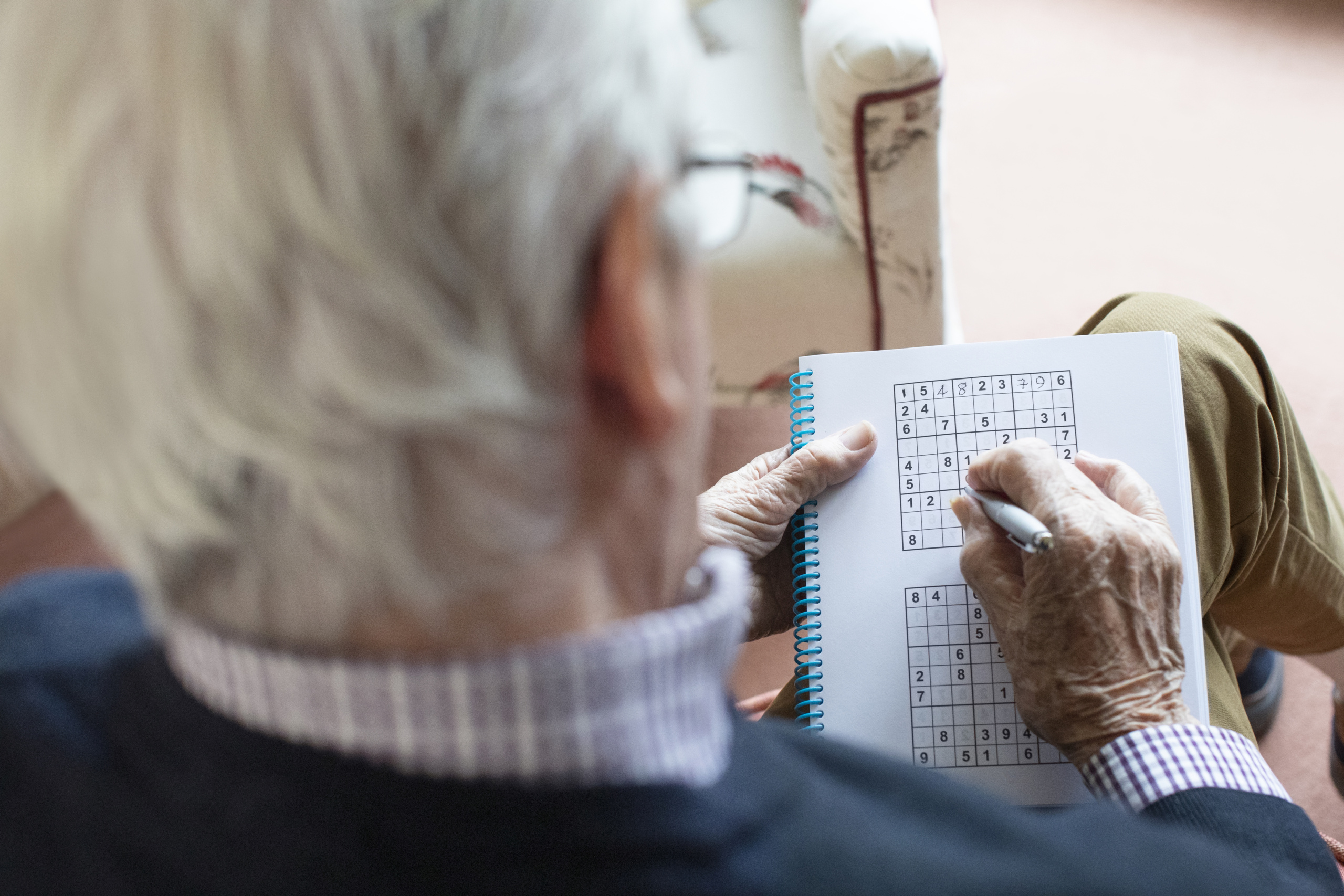 Mann løser sudoku. Foto