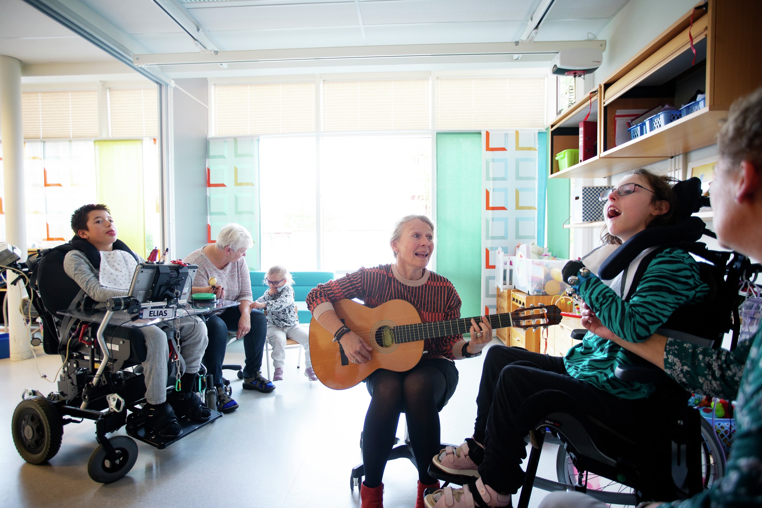 Musikk og gitar foran personer med utviklingshemning. Foto