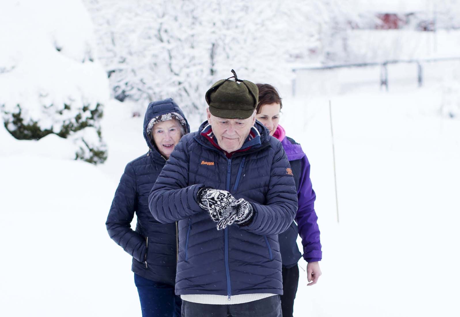 Eldre på rad i snøen. Foto.