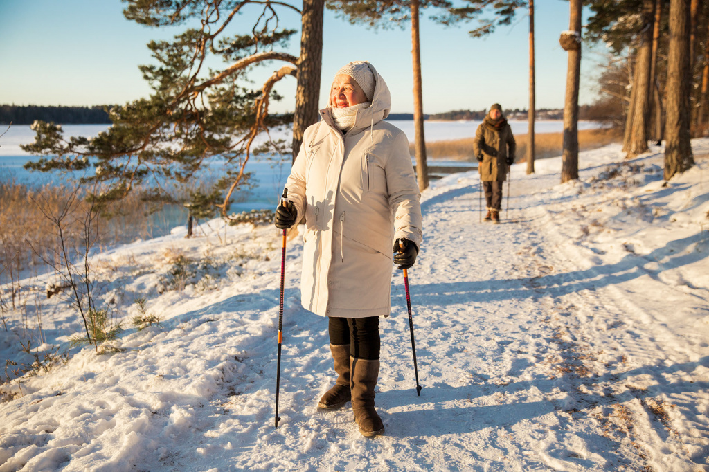 Eldre kvinne og mann med gåstaver om vinteren