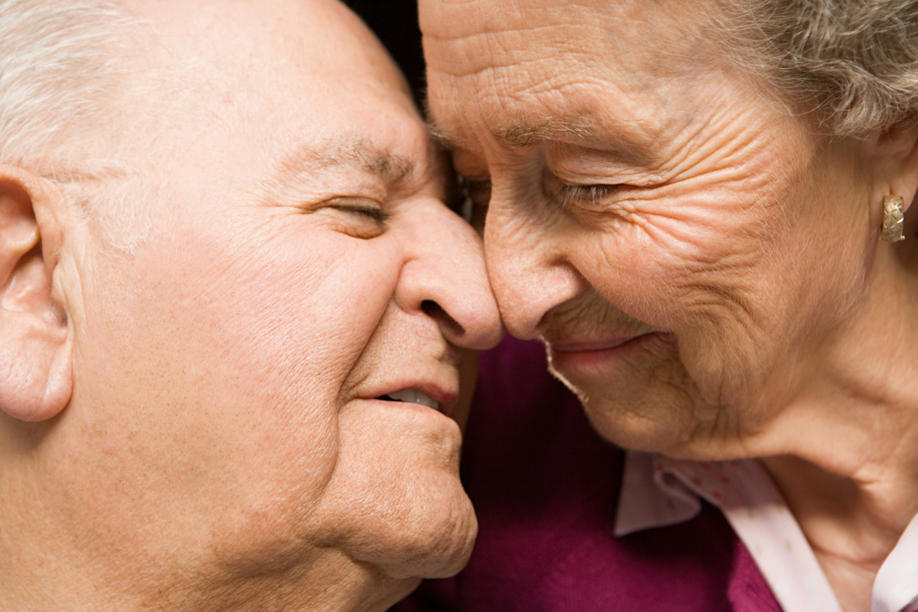 Eldre par viser kjærlighet, nese mot nese
