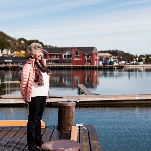 Eldre kvinne på brygge. Foto