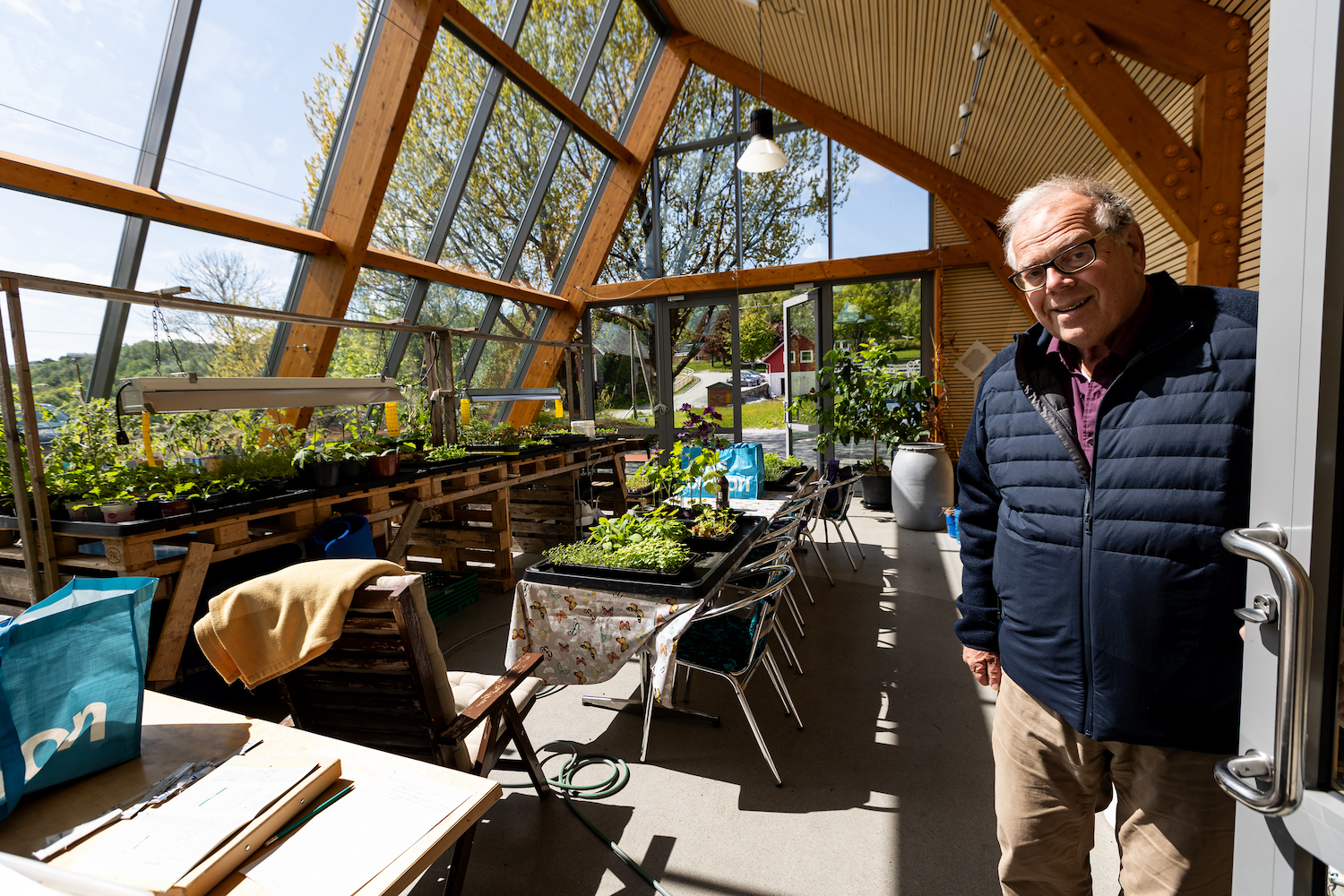 Mann viser fram urter i veksthuset utenfor boliger for eldre i Bergen
