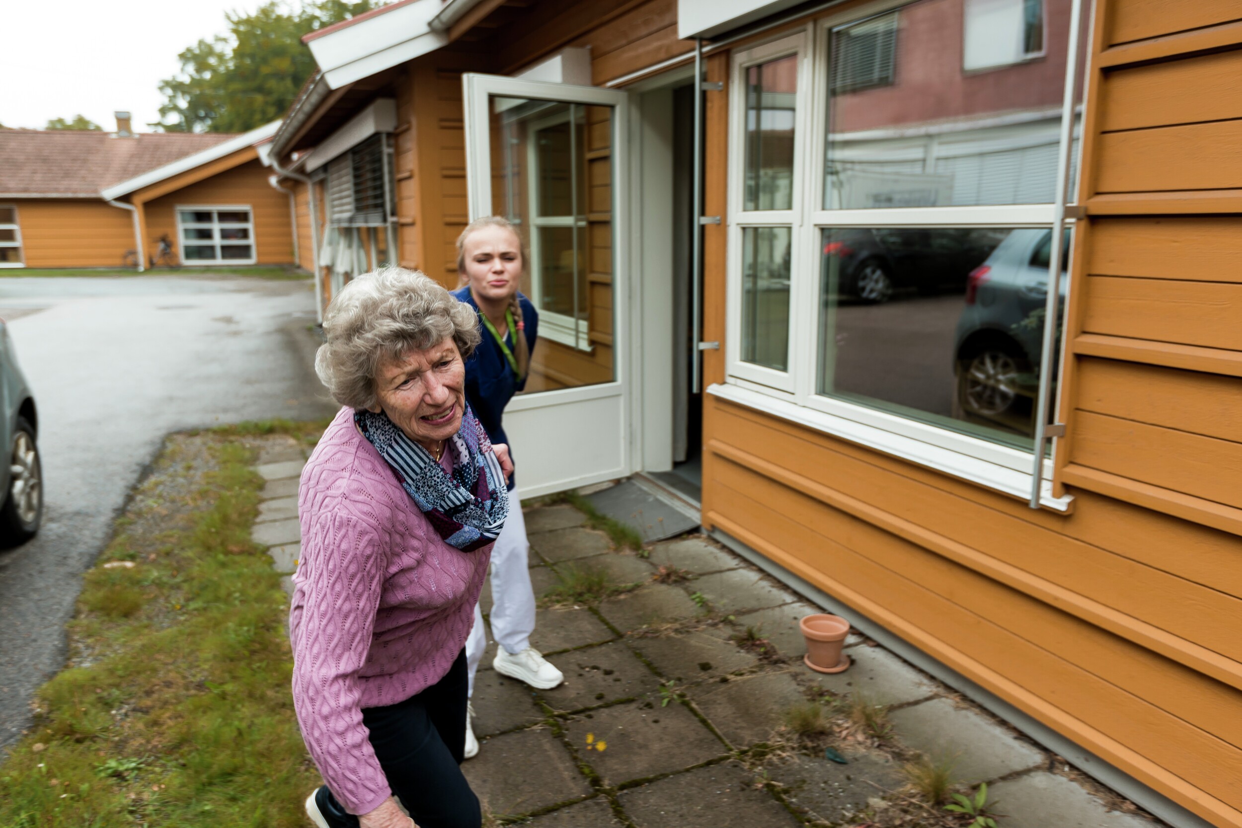 Kvinne holdes igjen av pleier. Illustrasjonsfoto.