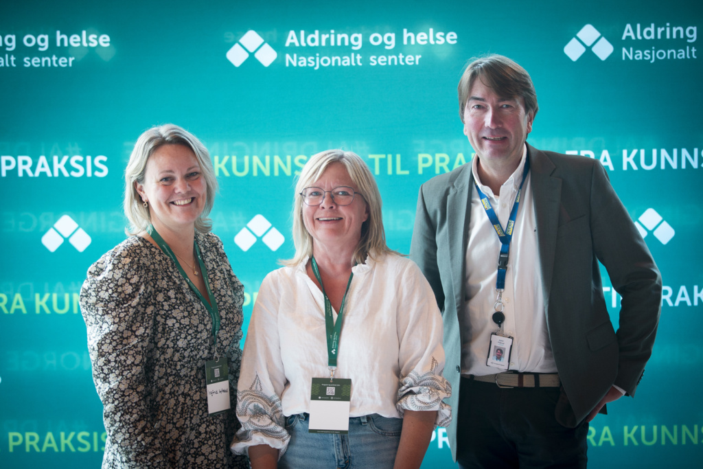 Tre personer foran Aldring og helse-logoer. Foto