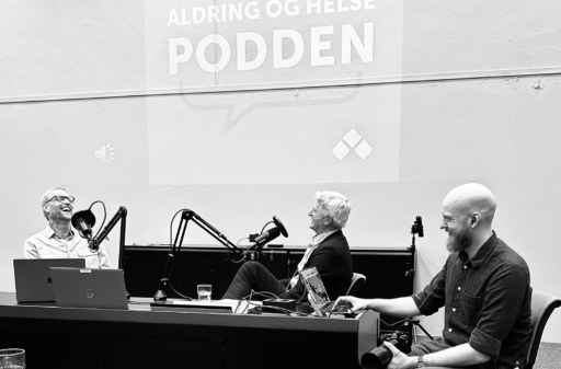 Tre menn på scene, som spiller inn podkast. Foto