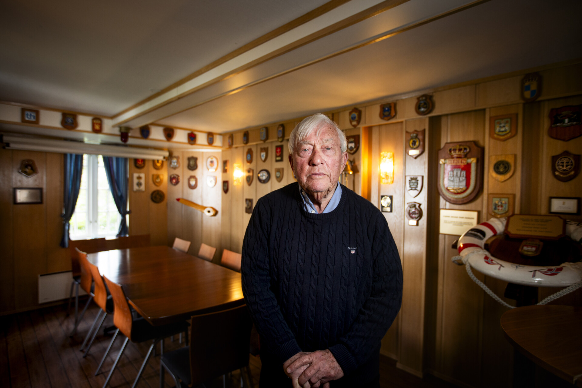 Eldre mann i rom med plaketter. Foto