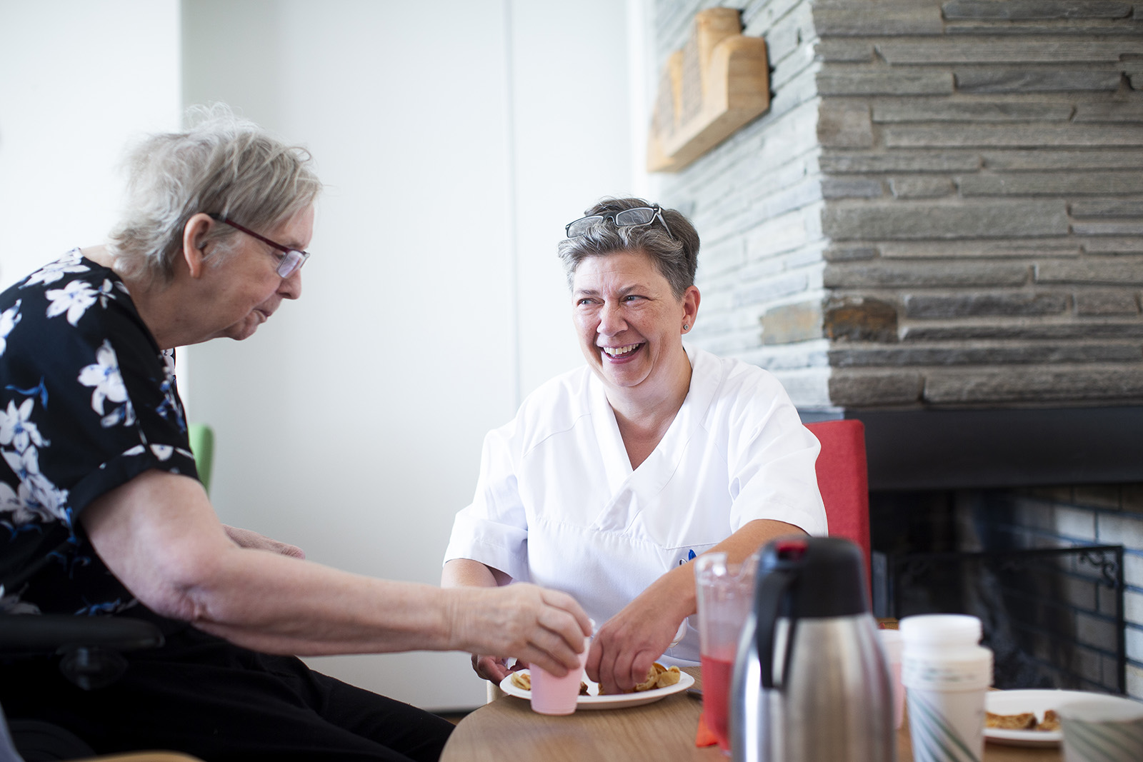 Eldre kvinne og sykepleier på sykehjem. Foto