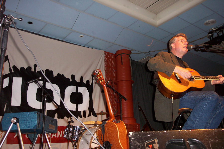 Mann spiller gitar på scene. Foto